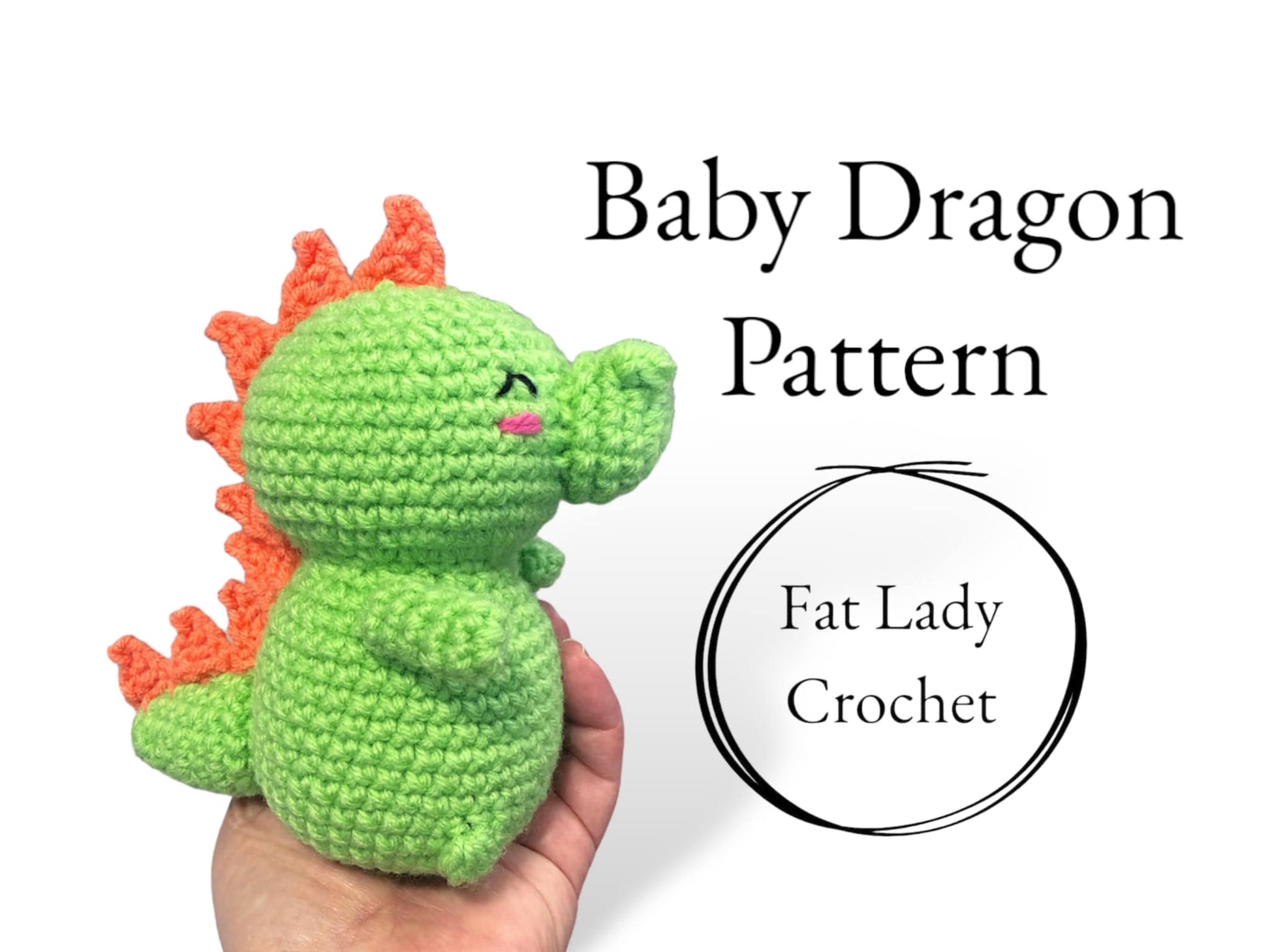 A small crochet baby dragon with a green body and orange spines, held in a person's hand with text that says "Baby Dragon Pattern," and "Fat Lady Crochet."