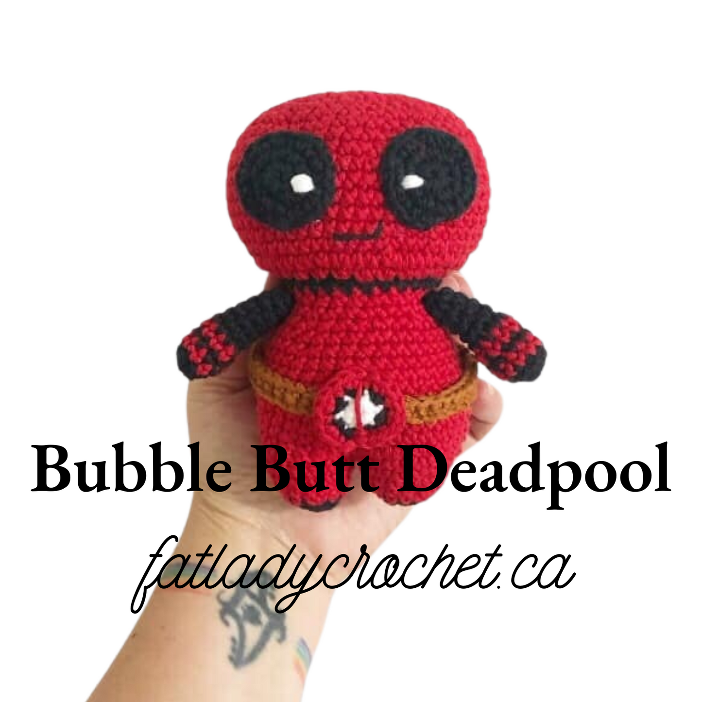 A crochet doll resembling Deadpool with a red and black color scheme and distinctive features such as large eyes and a belt.