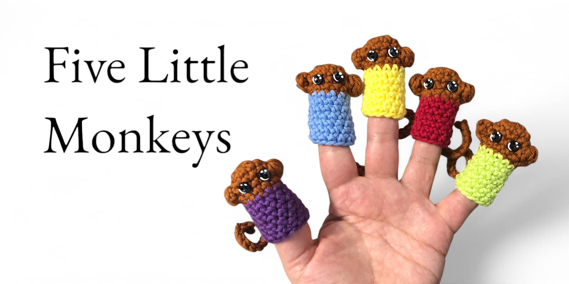 A hand displaying five little monkey finger puppets with different colored shirts in purple, yellow, blue, green, and red.