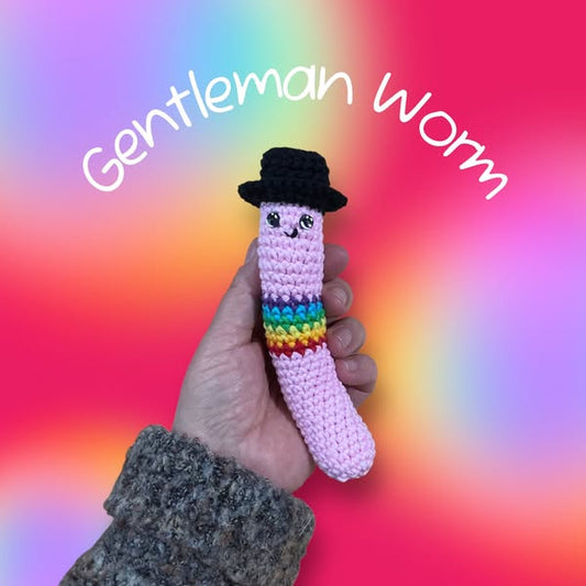 Hand holding a worm with rainbows around the body wearing a top-hat. He looks very gentle-manly, very polite looking man indeed!