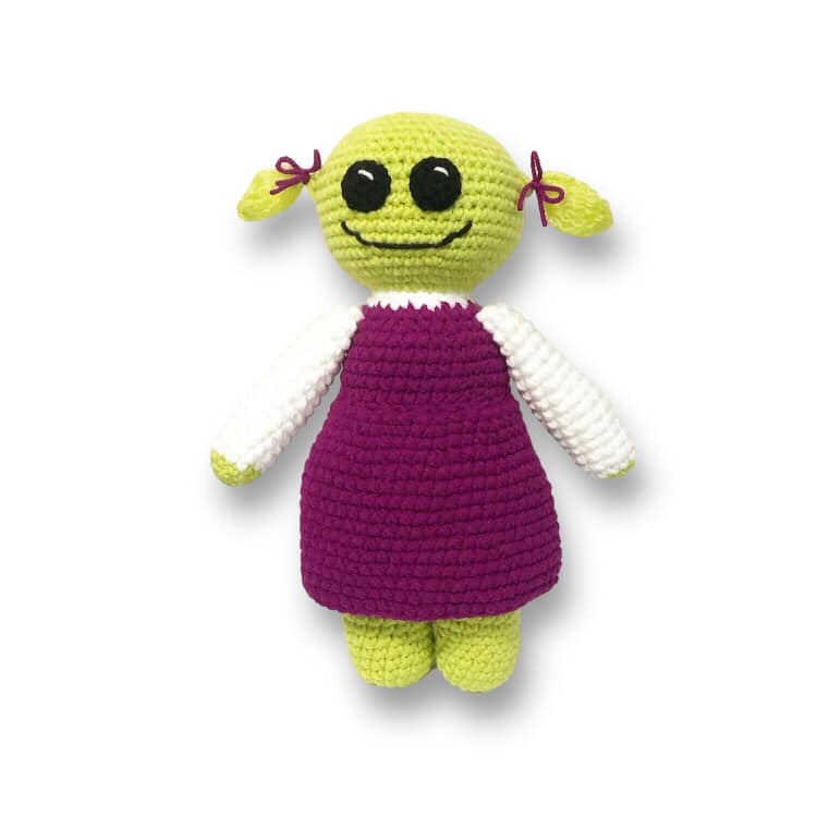 A crochet doll of Mona from Nanalan standing against a white background.