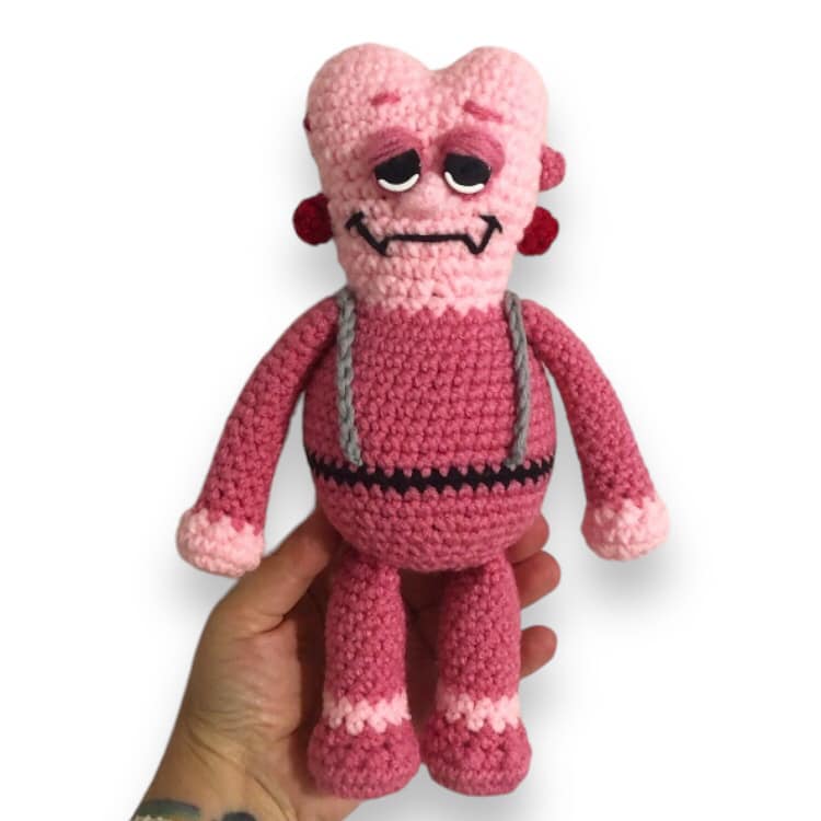 adorable! love those pinks! But for real, a crochet doll of Franken-Berry being held up against a white background.