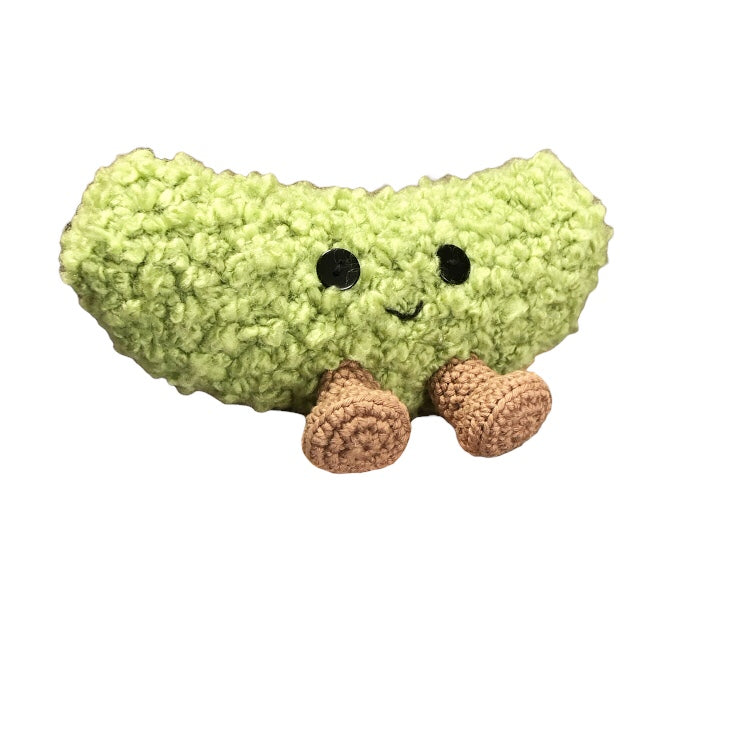 A dill pickle with a smiley face against a white backdrop