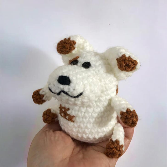 A crocheted plushie resembling Russel from Nanalan being held up against a white background.