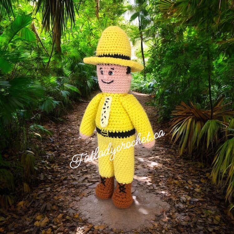 crocheted version of man in the yellow suit set against a jungle backdrop.