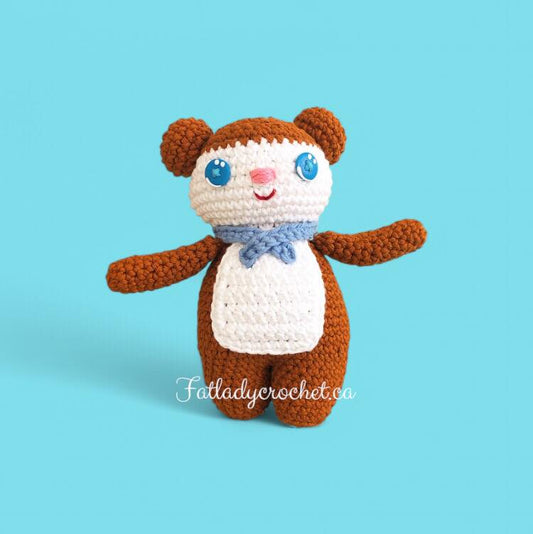 A small crochet bear named Jeremy with a brown back and white belly, wearing a blue scarf, displayed against a blue background.