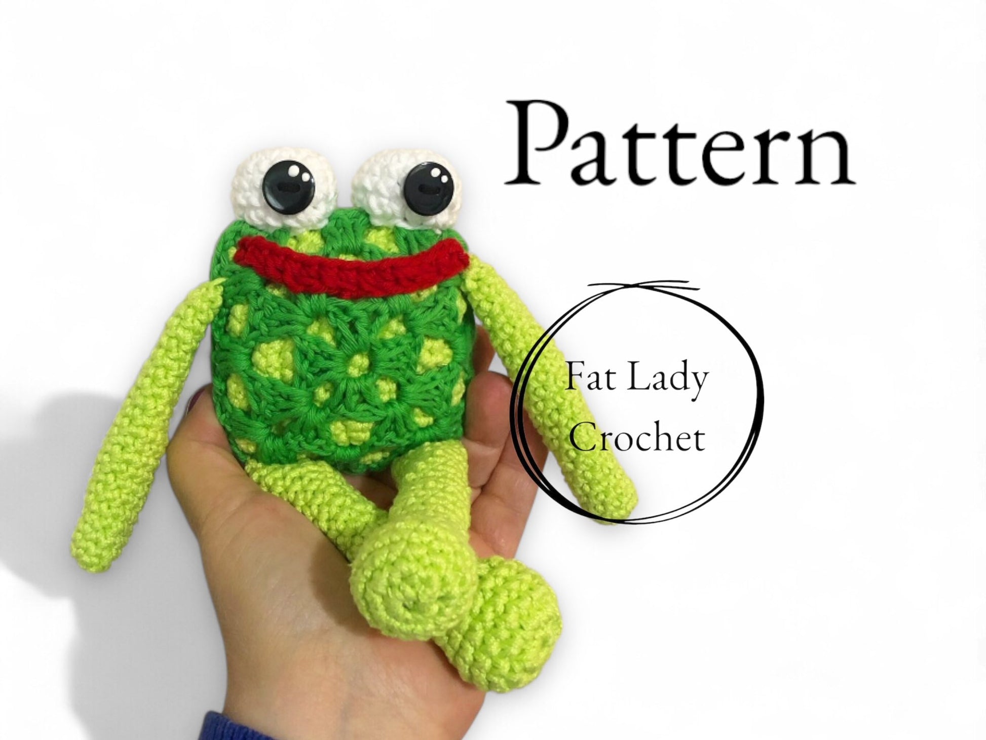 Hand holding a green crochet frog toy with 'Fat Lady Crochet' branding.