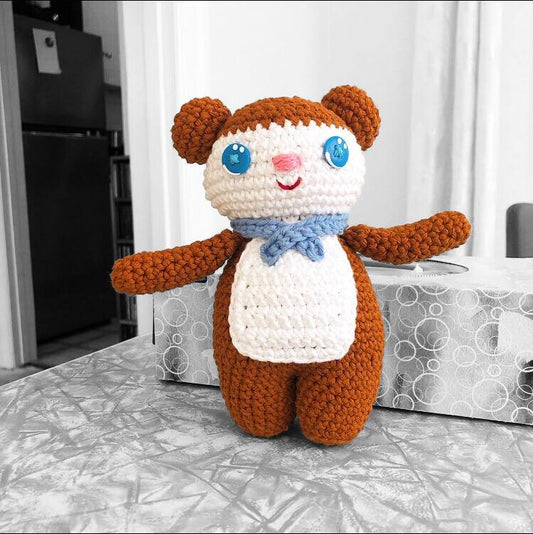 Jeremy Bear standing at a table, the background is in black and white. 