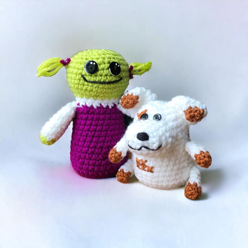 A pair of crochet plushies resembling Mona and Russel from Nanalan standing against a white background. 