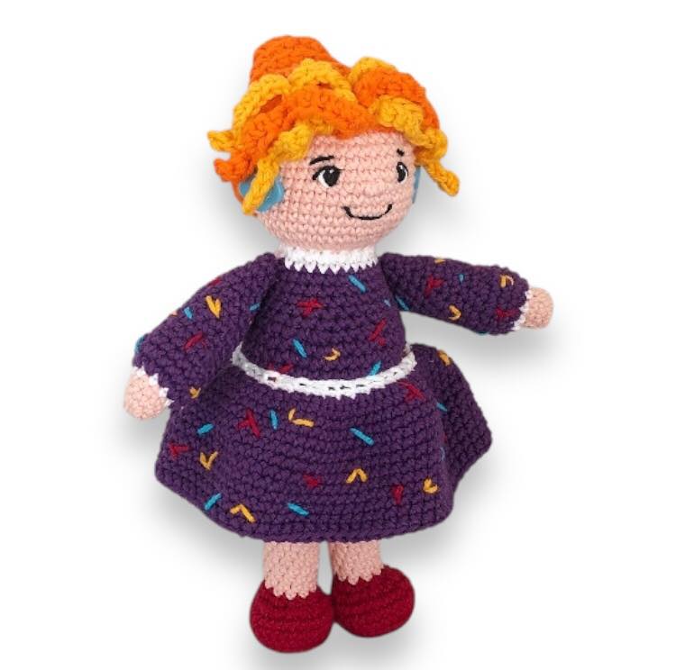Crocheted doll of Mrs. Frizzle on a white background