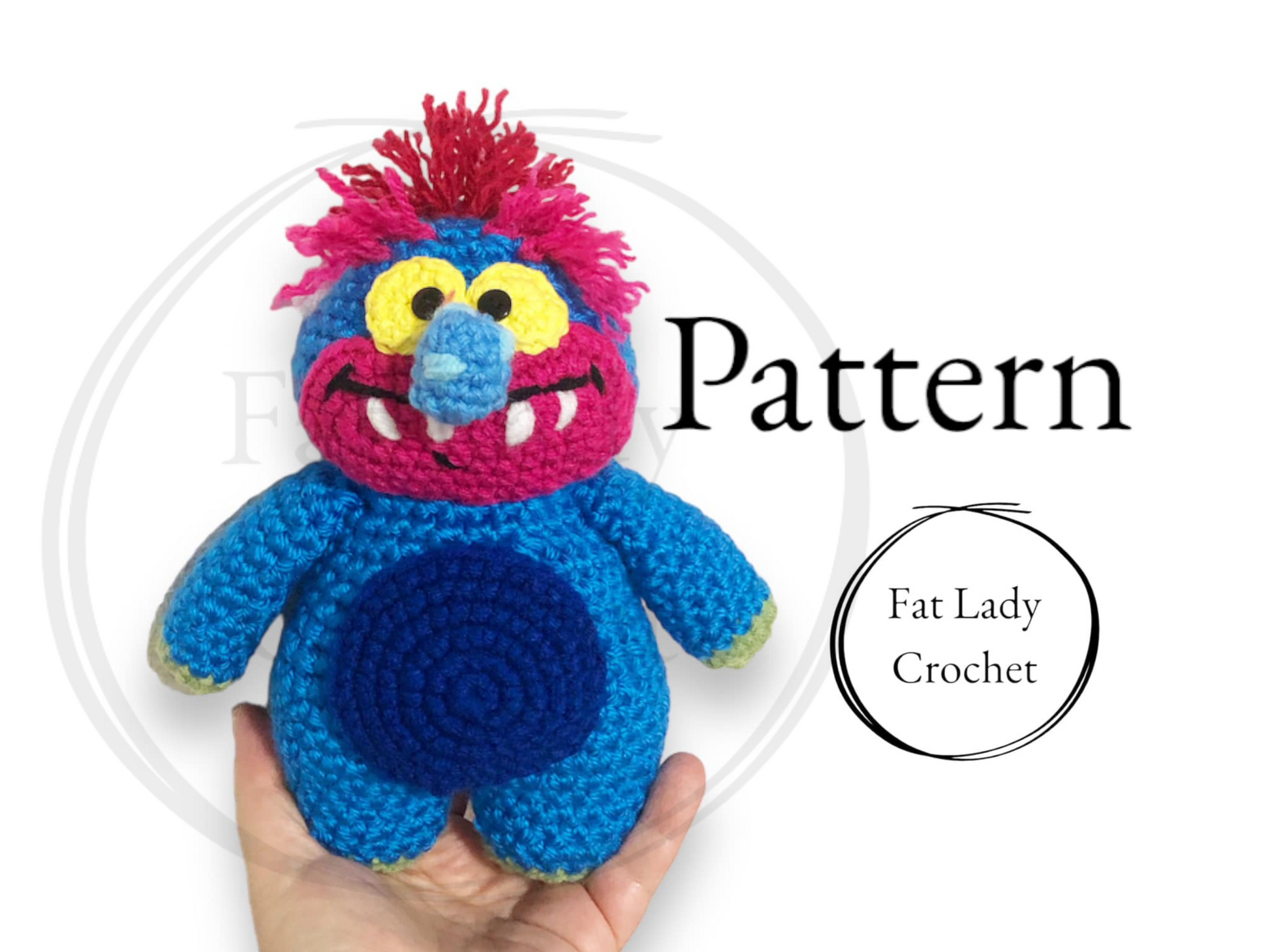 A crocheted blue monster with a long wart nose, pink and blue face with fangs and pink hair being held up against a white background with text that reads "Patterns," and "Fat Lady Crochet." 