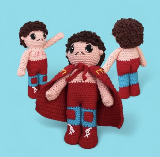 Crocheted doll of Ignacio from Nacho Libre with cape and boots on a blue background