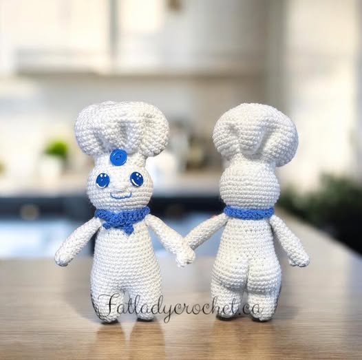 Crochet Pillsbury doughboy standing on a kitchen counter, one of them facing front, the other facing away