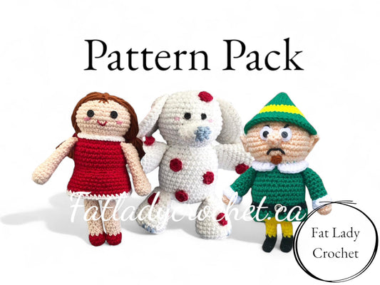 Three crochet dolls resembling some cast members from Rudolph the Red-Nosed Reindeer cast. A crocheted doll in a red dress, a white elephant with red spots, and a grumpy elf with a goatee and green outfit. 