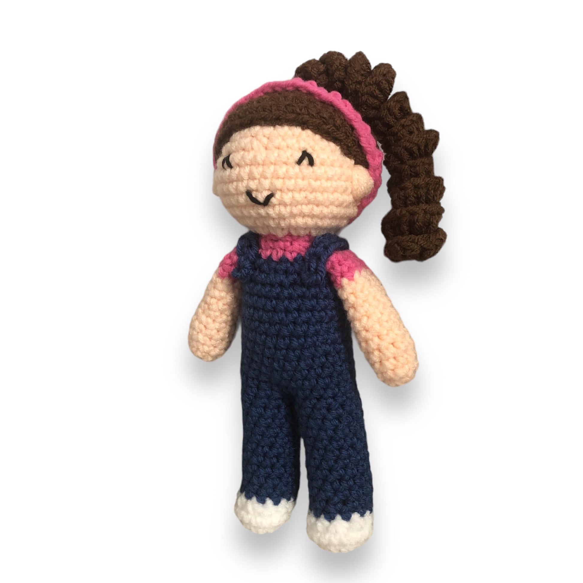 A crocheted doll resembling the kids content creator Ms. Rachel being standing against a white background
