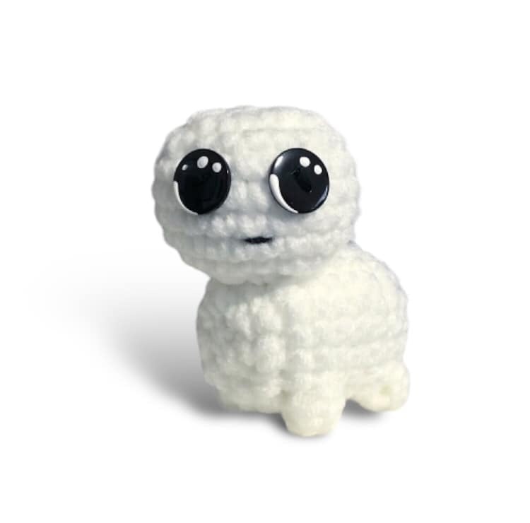 A crocheted version of the tbh creature standing against a white background. 