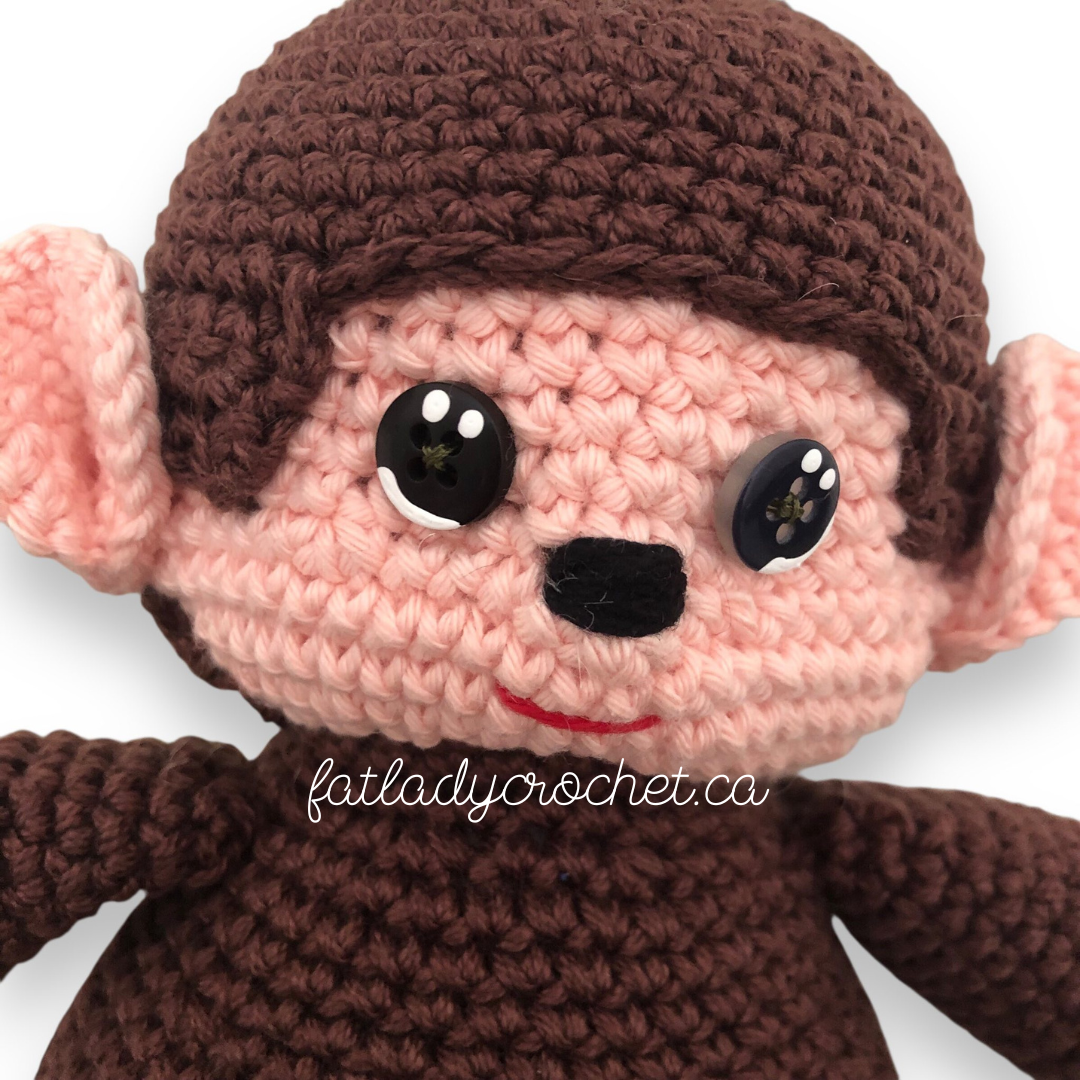 An even closer close up of the crochet monchhichi doll against a white background. (Woah! Crazy!)